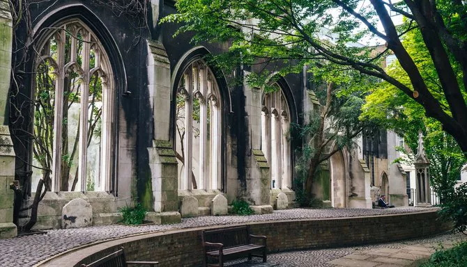 A stone bench located in the middle of a park, offering a place to sit among greenery