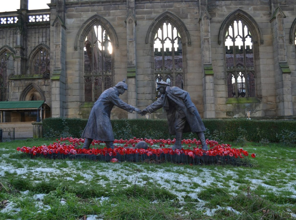 a statue of two people shaking hands in front of a building