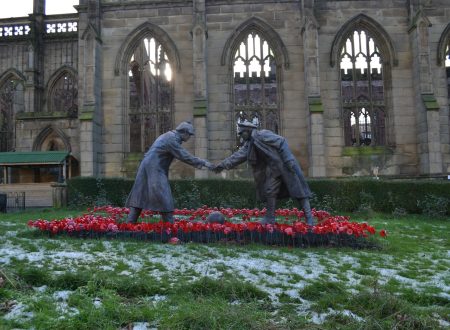 a statue of two people shaking hands in front of a building